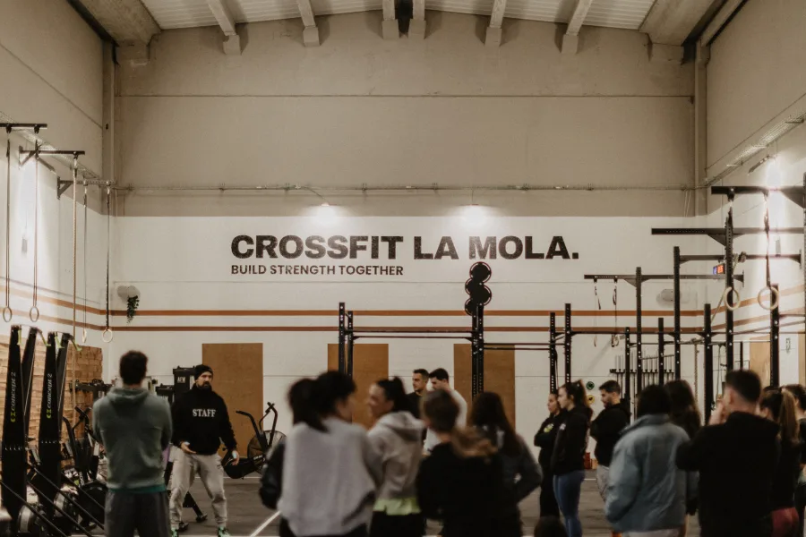 Classe WOD a CrossFit La Mola amb grup d'atletes i coach explicant el workout